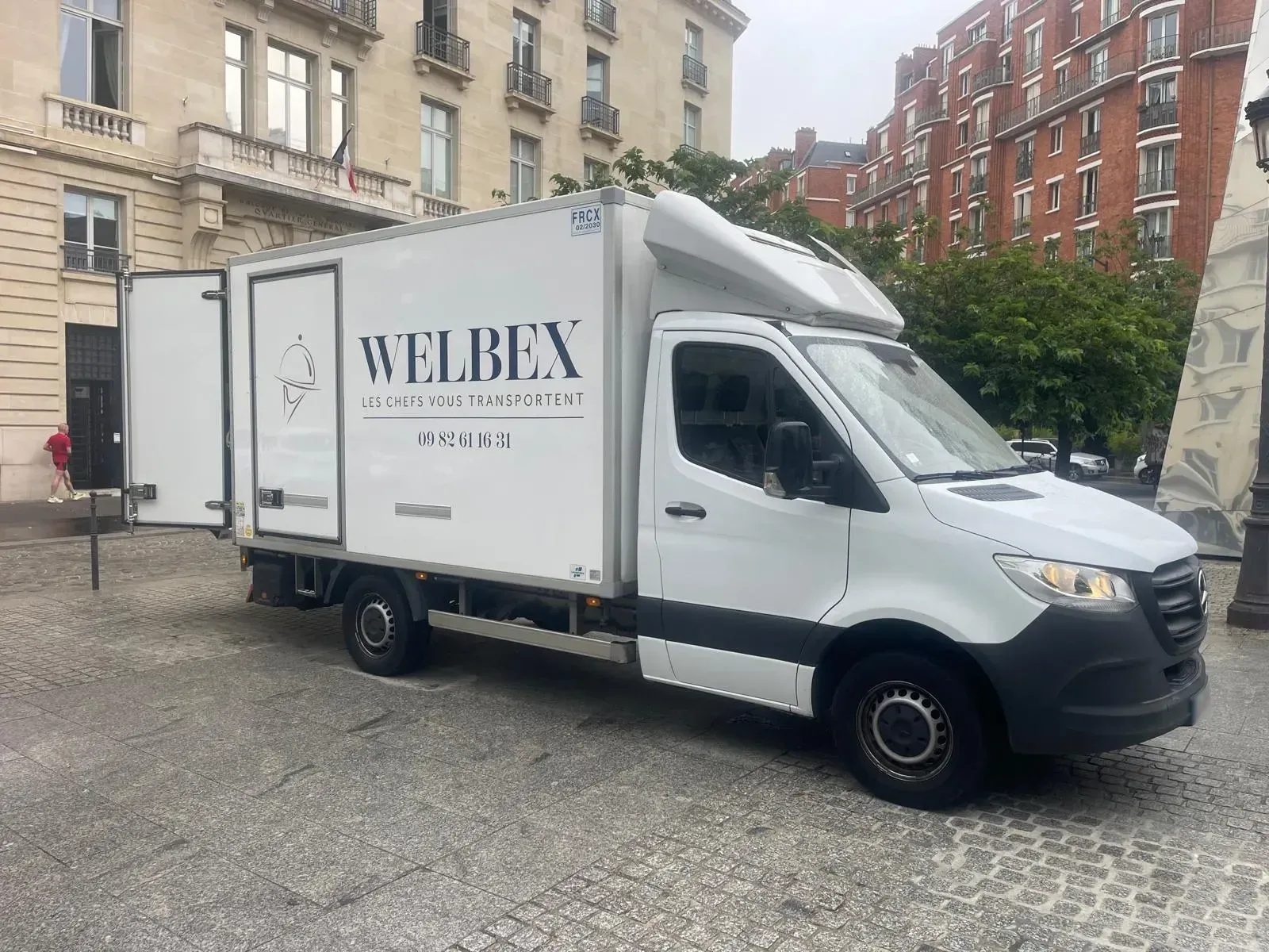 Camion Welbex dans une rue haussmannienne
